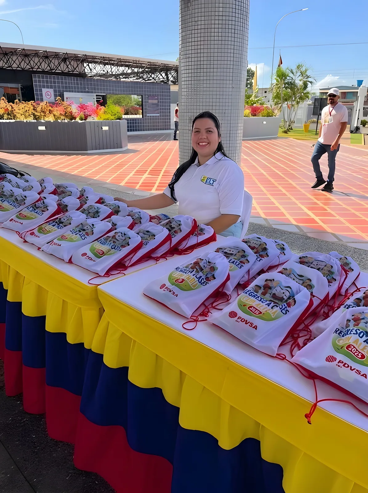Integrante del equipo sonríe junto a la mesa de morrales.